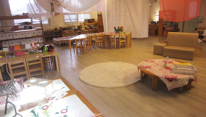 라이트박스와 책상, 의자가 있고 바닥엔 하얗고 둥근 카펫이 깔린 교실의 모습이다