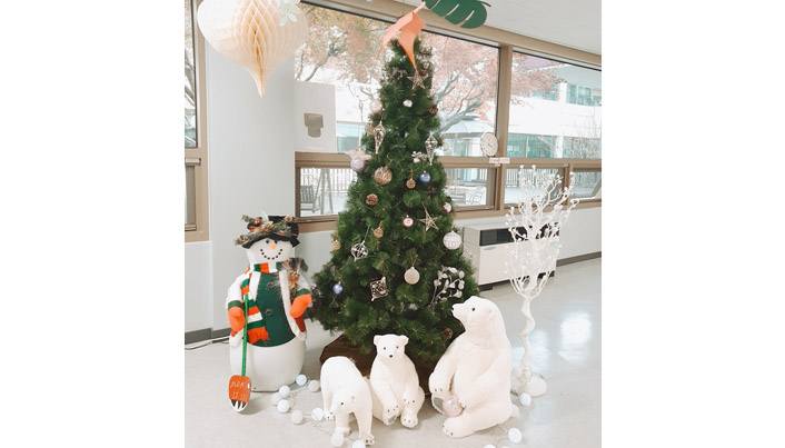 크리스마스 트리와 장식된 눈사람과 북극곰 인형들이 있는 장면이다.