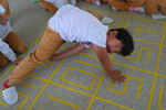 바닥에 써진 숫자를 이용해 트위스트 게임을 하며 웃고 있는 남자아이의 모습이다