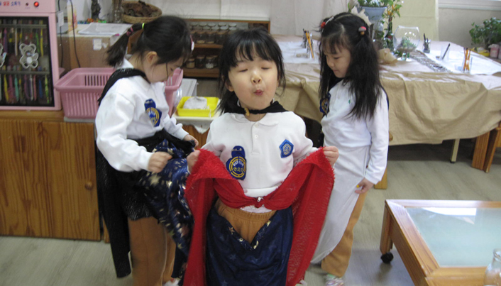 별무늬 치마를 입고 빨간 천을 허리에 두르거나 검은 망토를 맨 아이들의 모습이다