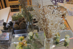 여러 종류의 꽃과 솔방울 등 다양한 식물이 책상 위에 놓여져있다