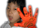 주황색과 녹색 물감이 묻은 손을 들고 있는 여자아이의 모습이다