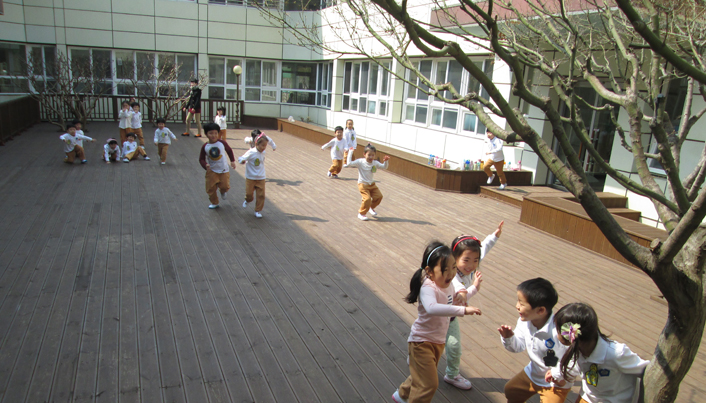 아이들이 교실밖에서 잡기놀이를 하고 있다