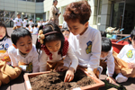아이들이 모여 화분 속의 흙을 만져보고 있다